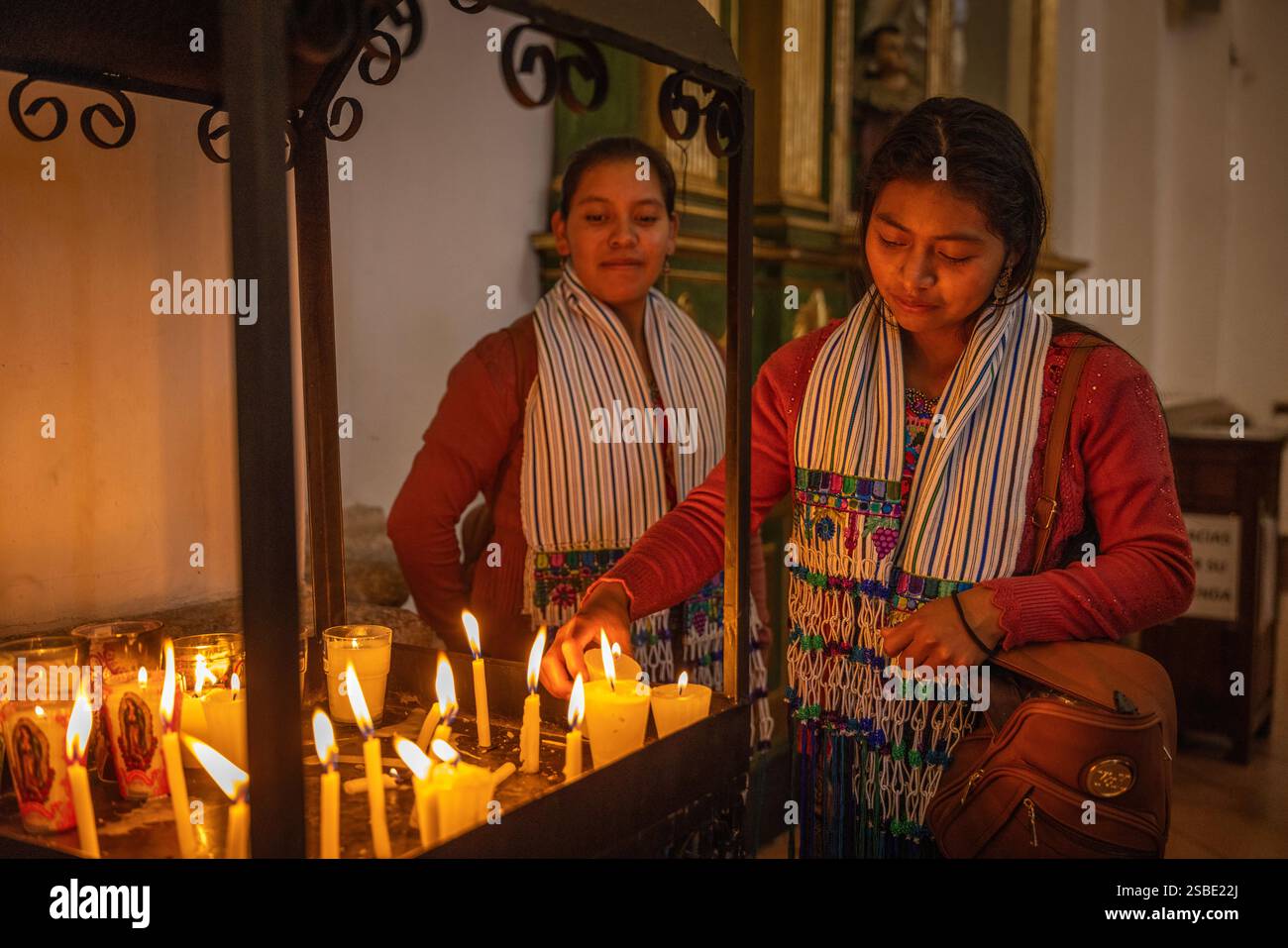 Guatemalan women lighting candles in the Cathedral of San Jose, Antigua, Guatemala Stock Photo