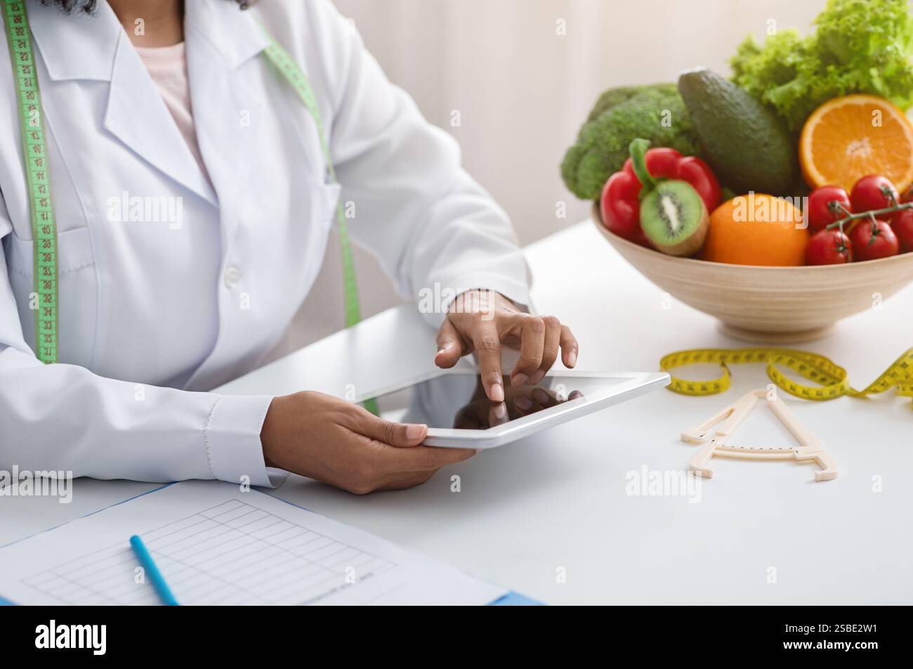 Dietologist black woman using digital tablet at workplace Stock Photo