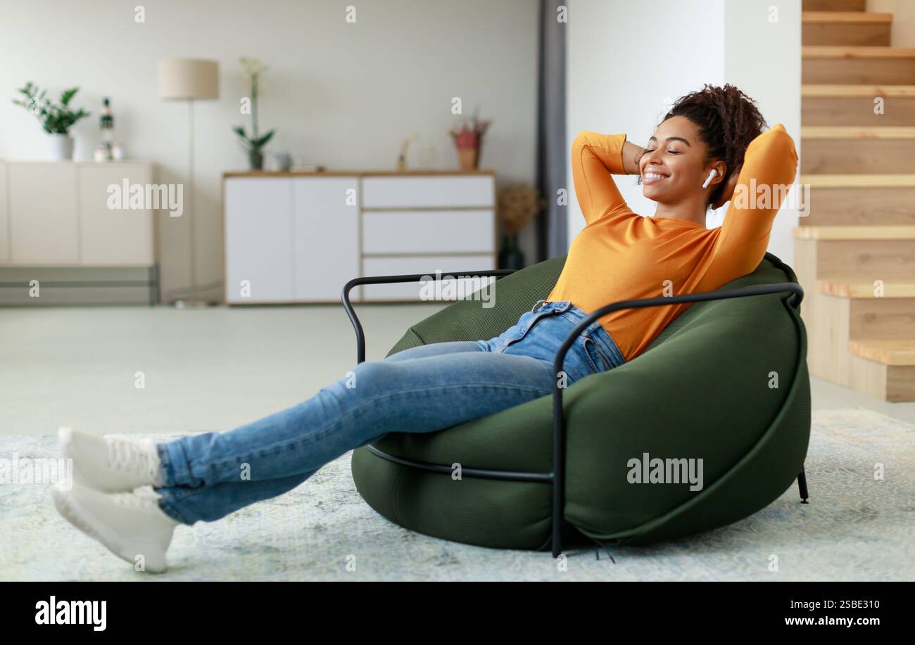 Calm black woman having rest at home on bean bag Stock Photo