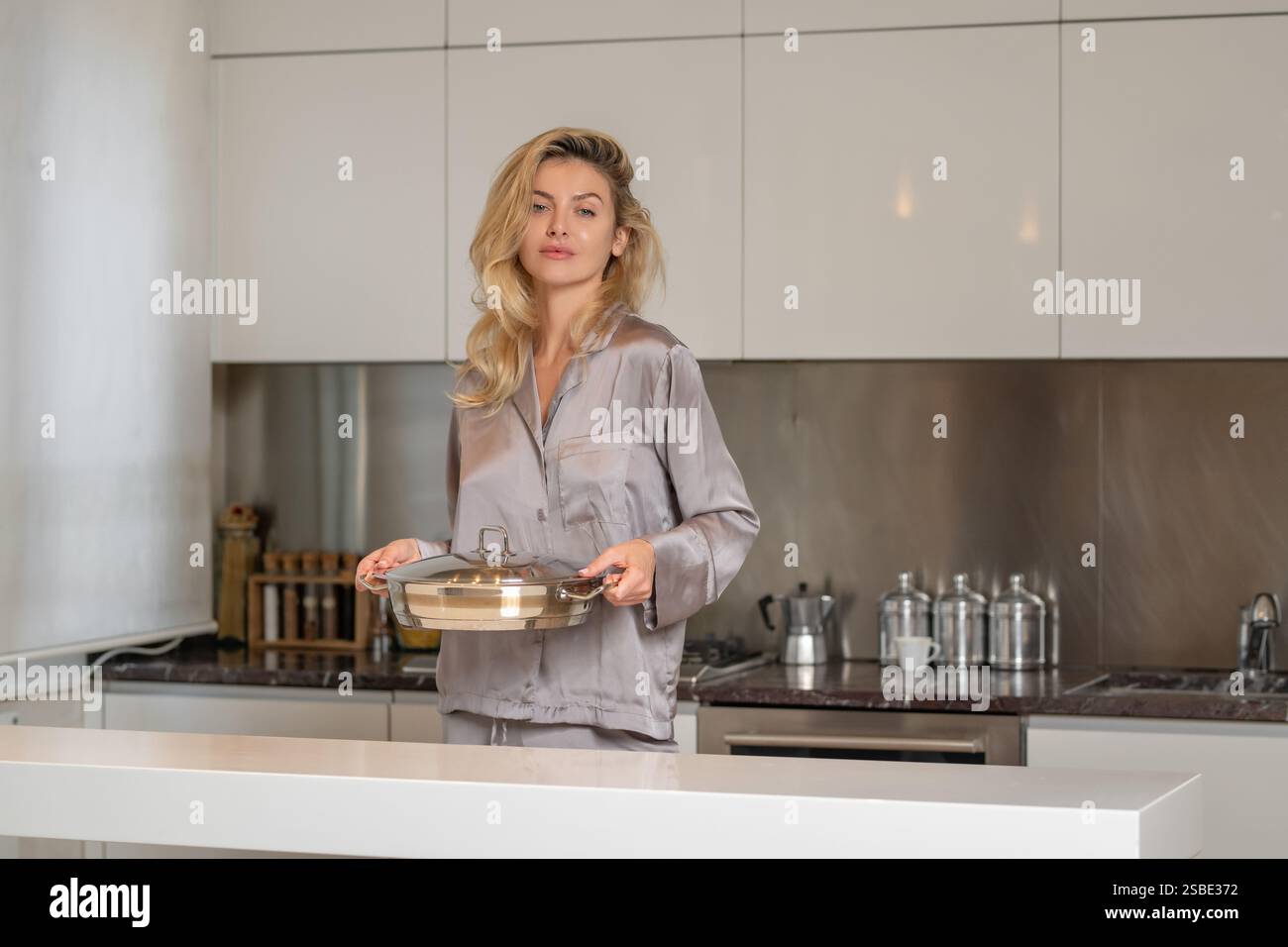 Woman in the modern kitchen in the morning. Portrait of a pretty young ...