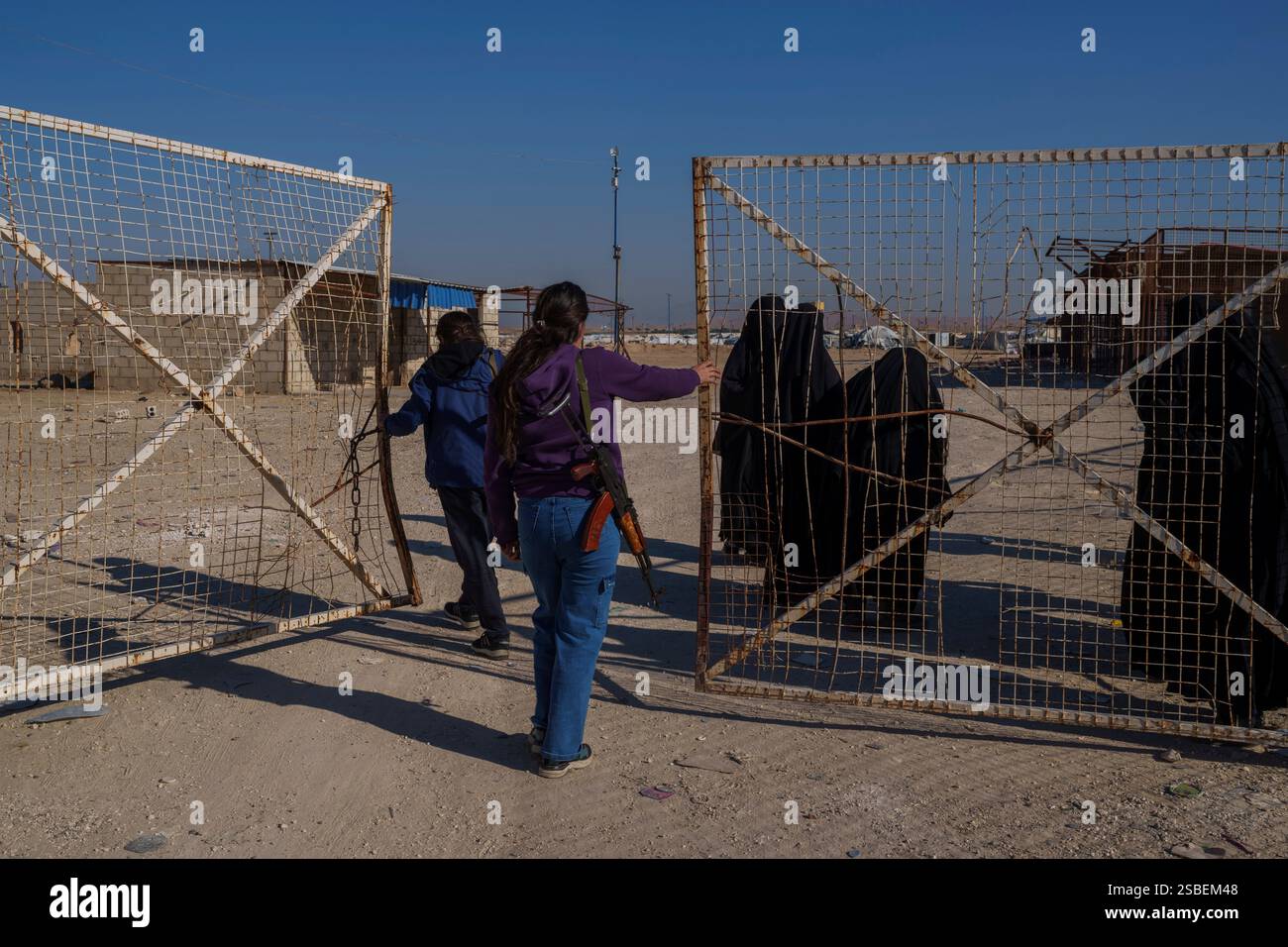 Members of the Syrian Democratic Forces open a gate of the al-Hol ...