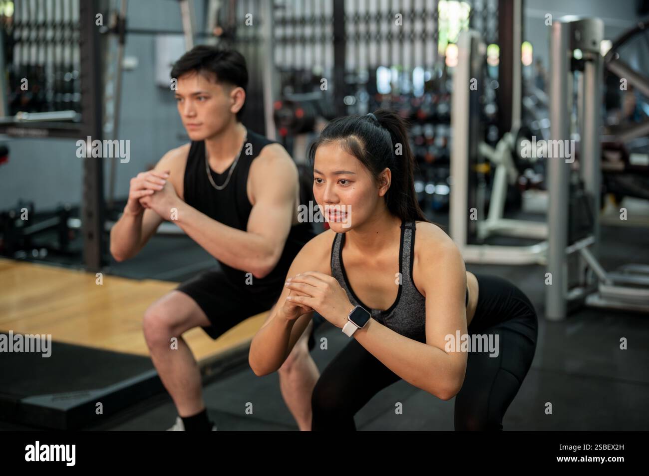 A side view of a sporty, determined Asian couple in sportswear is ...