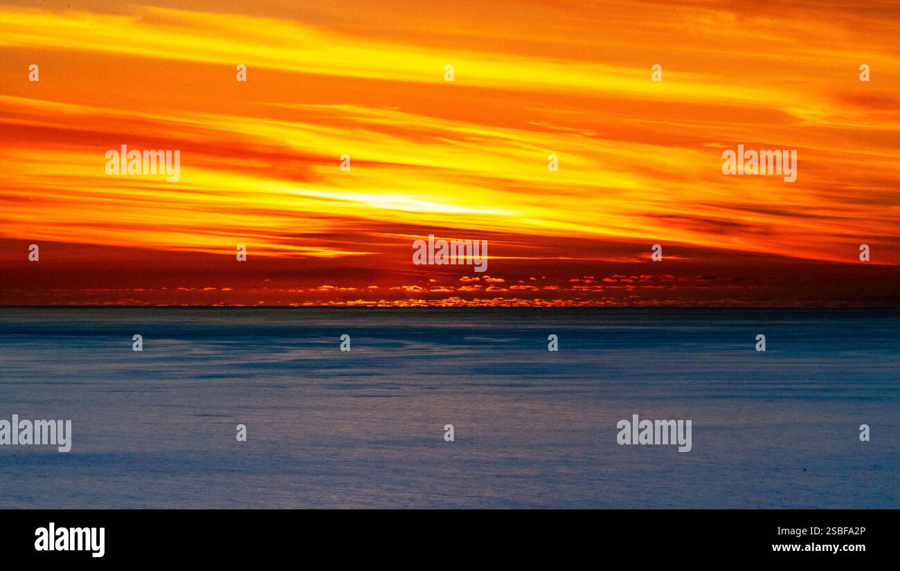A stunning sunset over the ocean, featuring vibrant orange and yellow ...