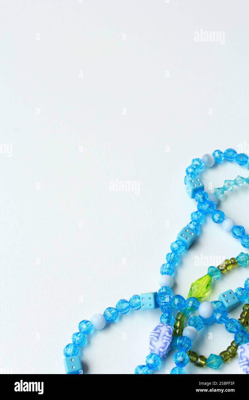Vertical abstract background with copy space, featuring vibrant green and blue acrylic bead necklaces. Ideal for Brazilian Carnival festive costumes. Stock Photo