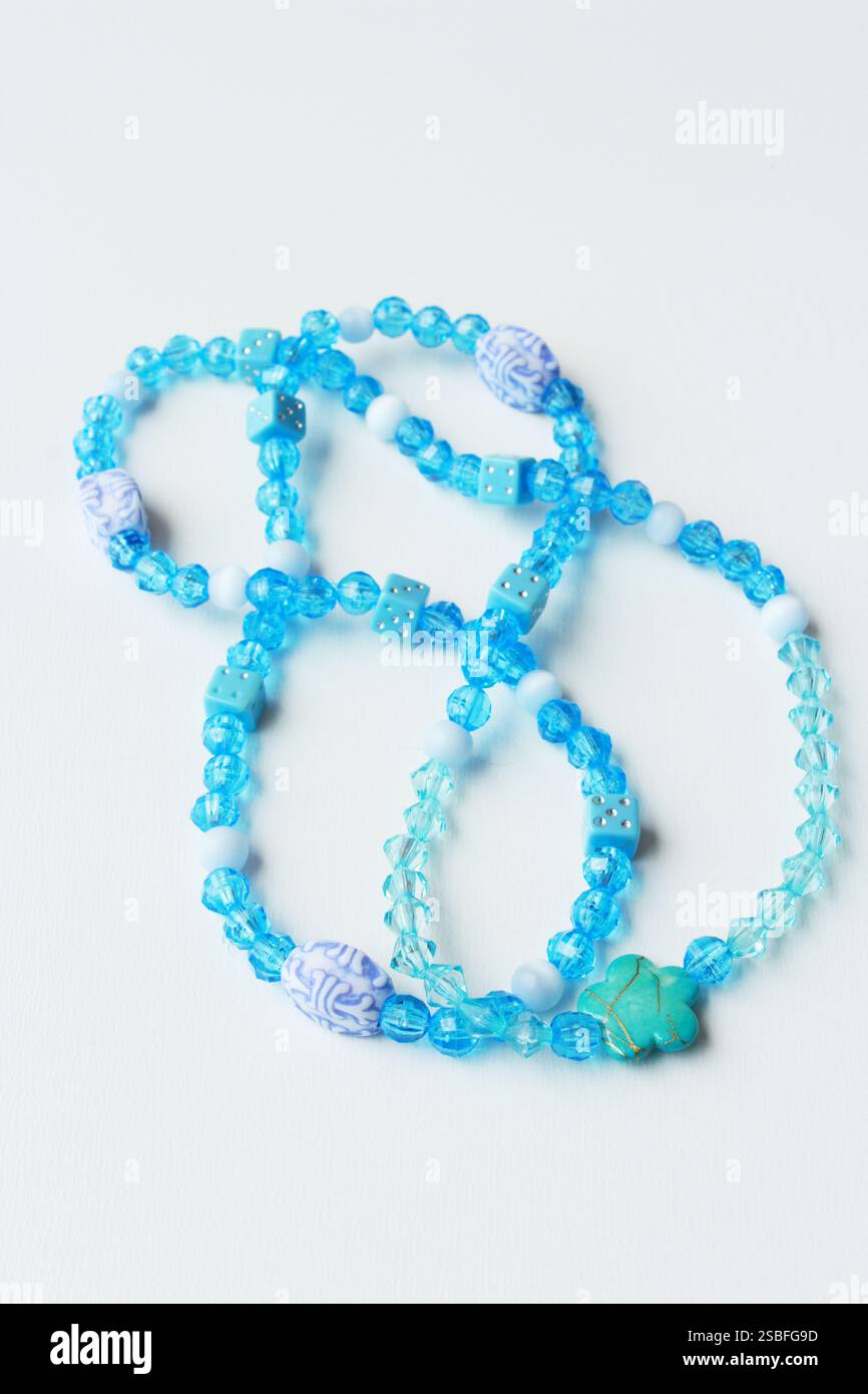 Blue bead necklace arranged in infinity shape. Color, delicate, handmade female fashion accessory for brazilian carnaval. Stock Photo