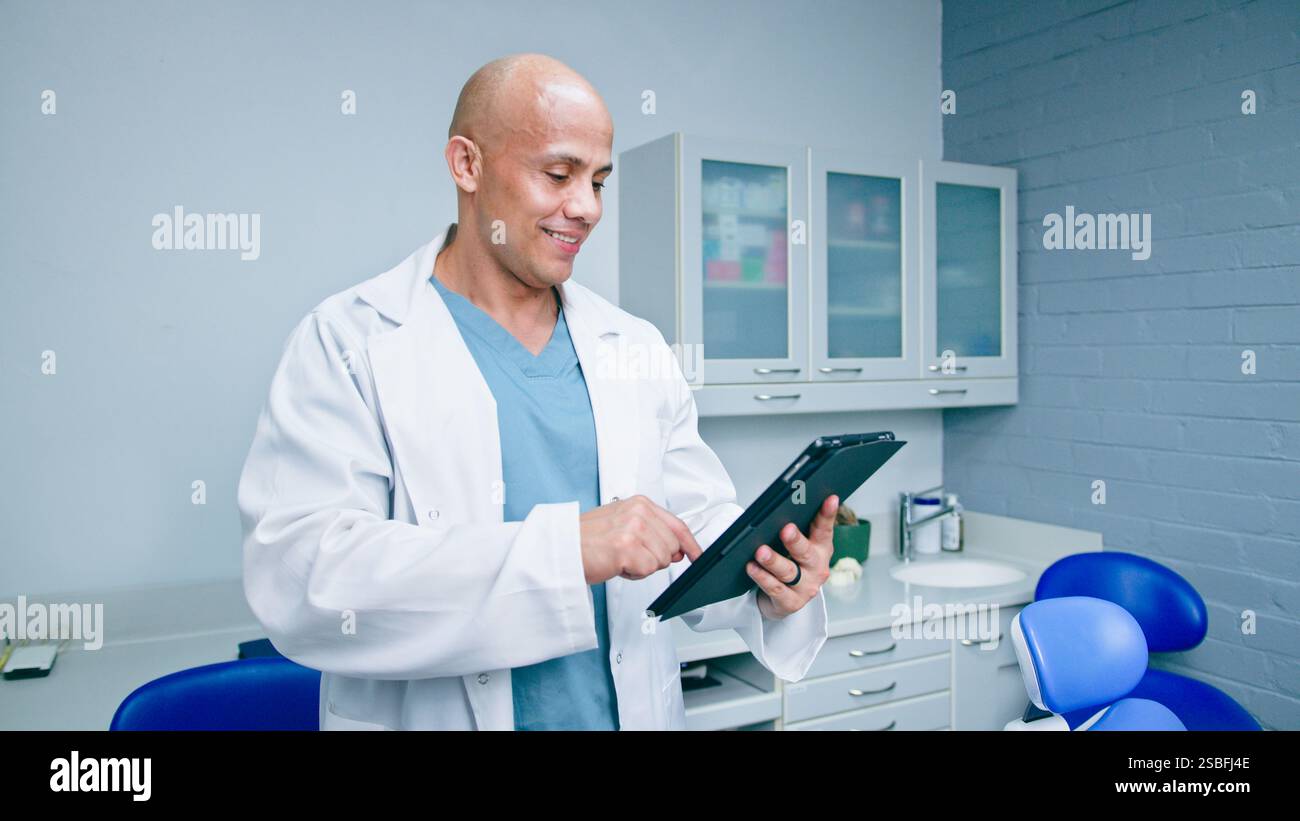 Professional Dentist Using a Tablet in a Modern Clinic Environment Stock Photo