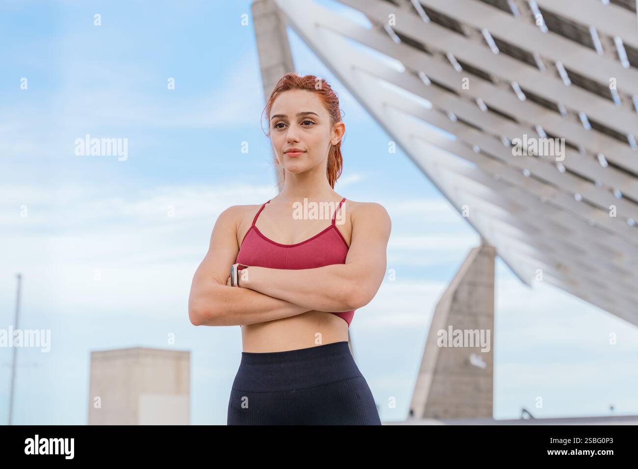 Confident Athletic Woman Posing Outdoors with Modern Architecture in Background Stock Photo