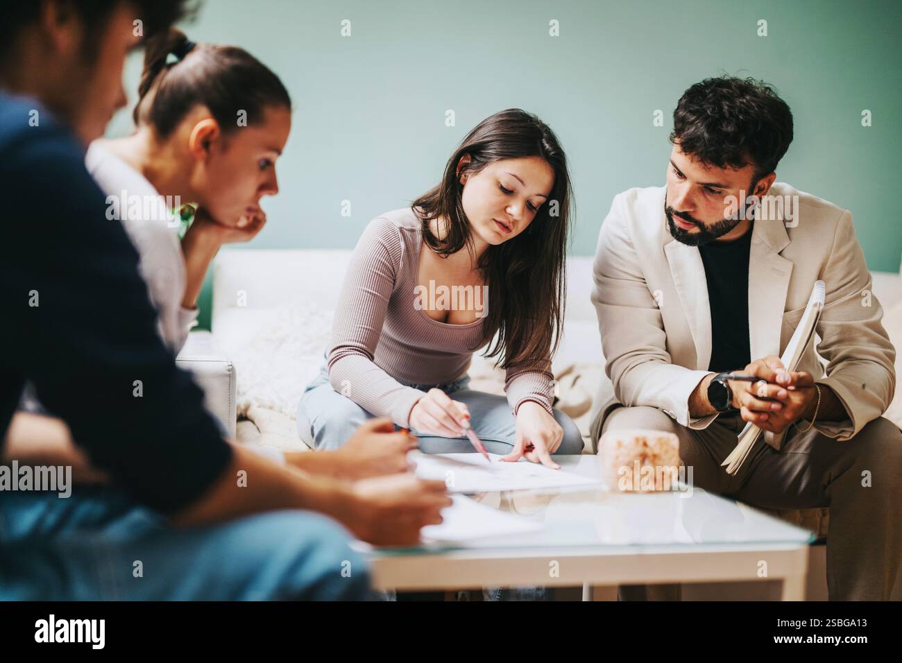 High school students collaborating on projects with professor after school Stock Photo