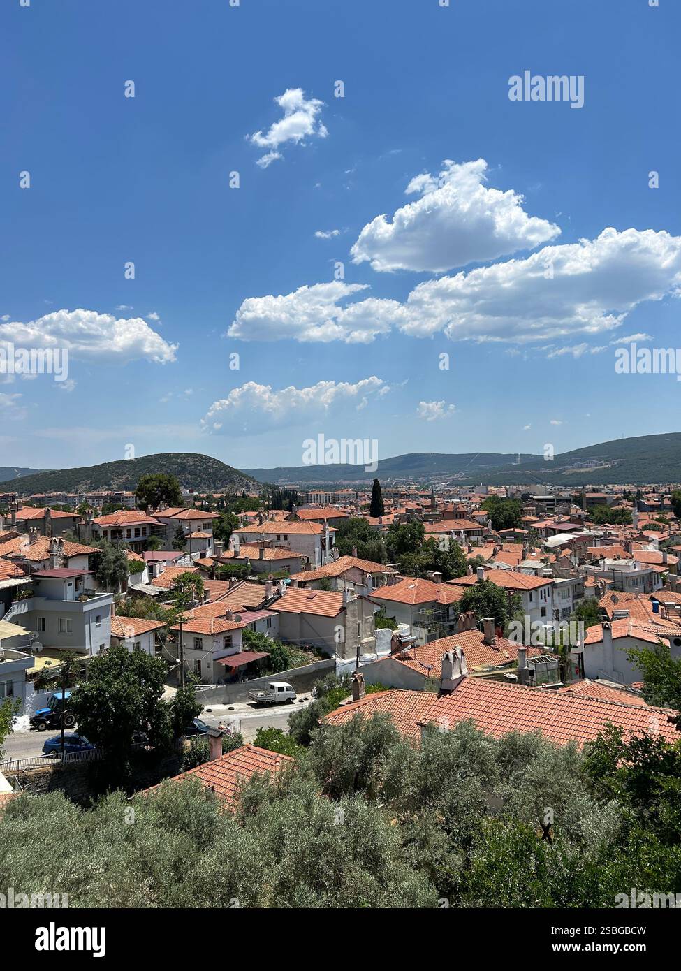 Views of a quaint town surrounded by mountains and trees - Smartphone Captured Stock Image