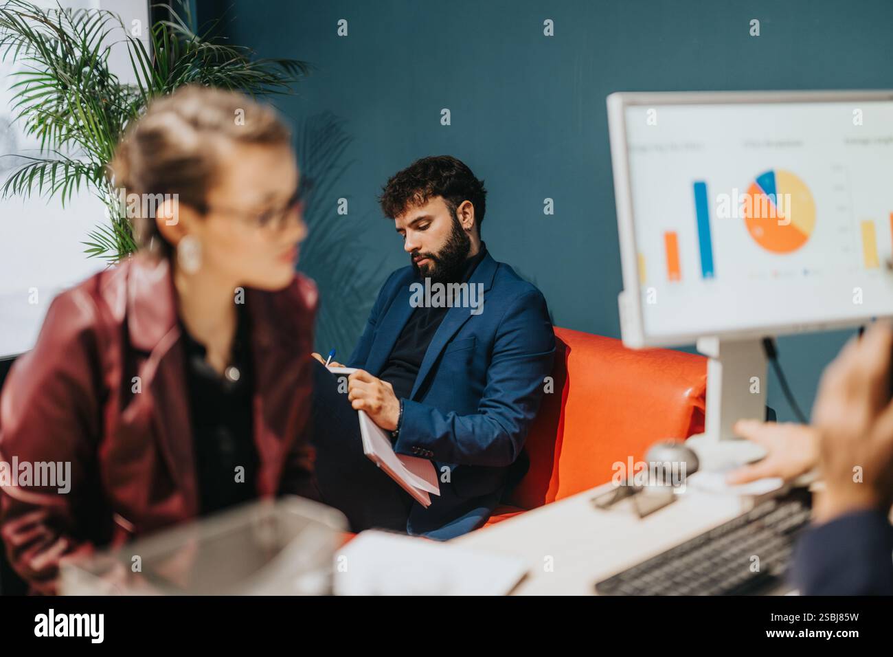 Team Members Collaborating and Analyzing Data in a Modern Office Setting Stock Photo