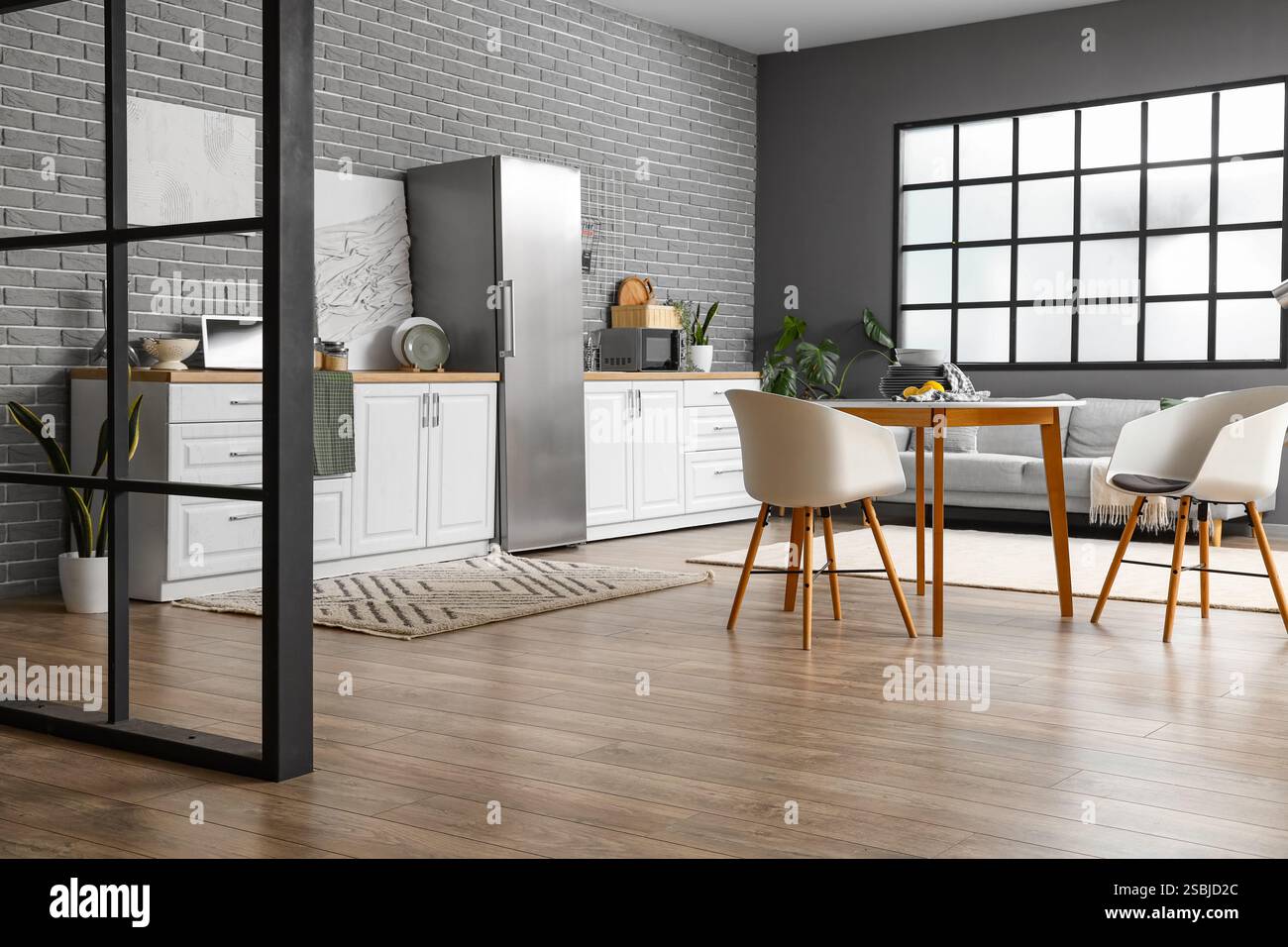 Interior of light kitchen with stylish fridge, counters, table and ...