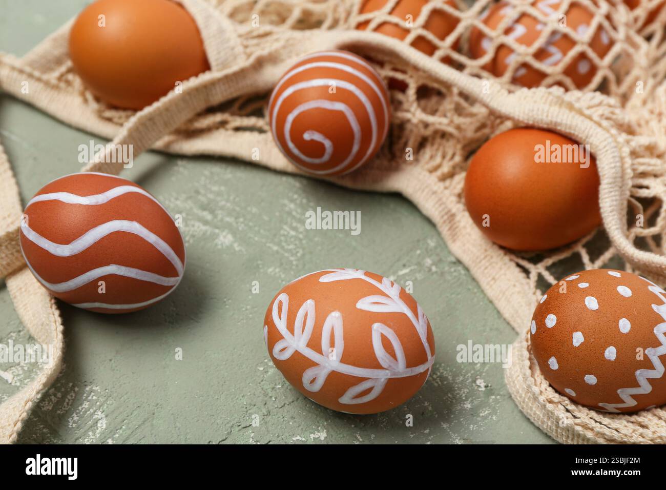 String bag with painted Easter eggs on grey background Stock Photo