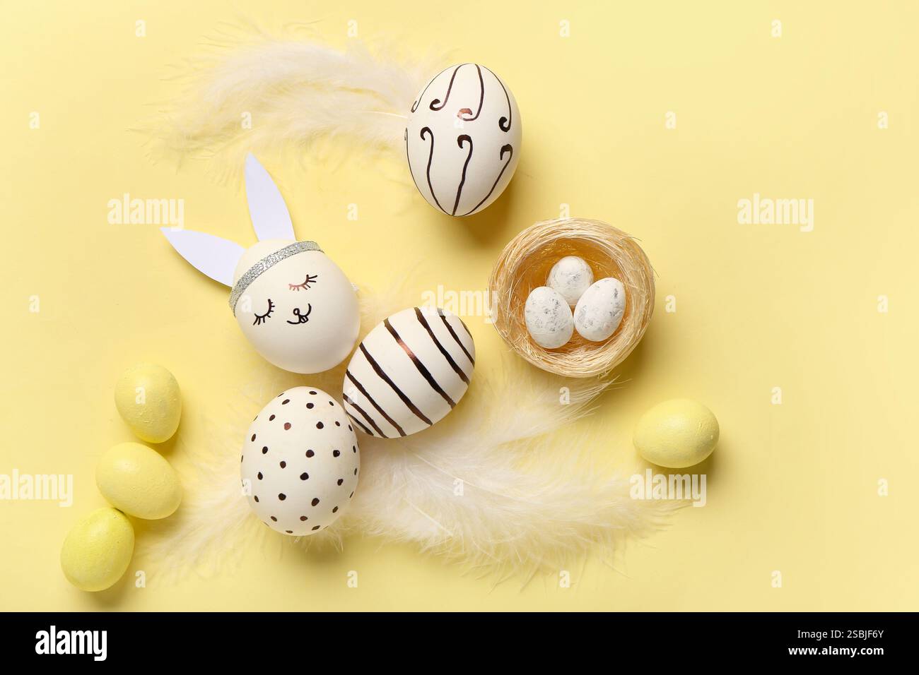 Composition with different creative Easter eggs and feathers on beige background Stock Photo