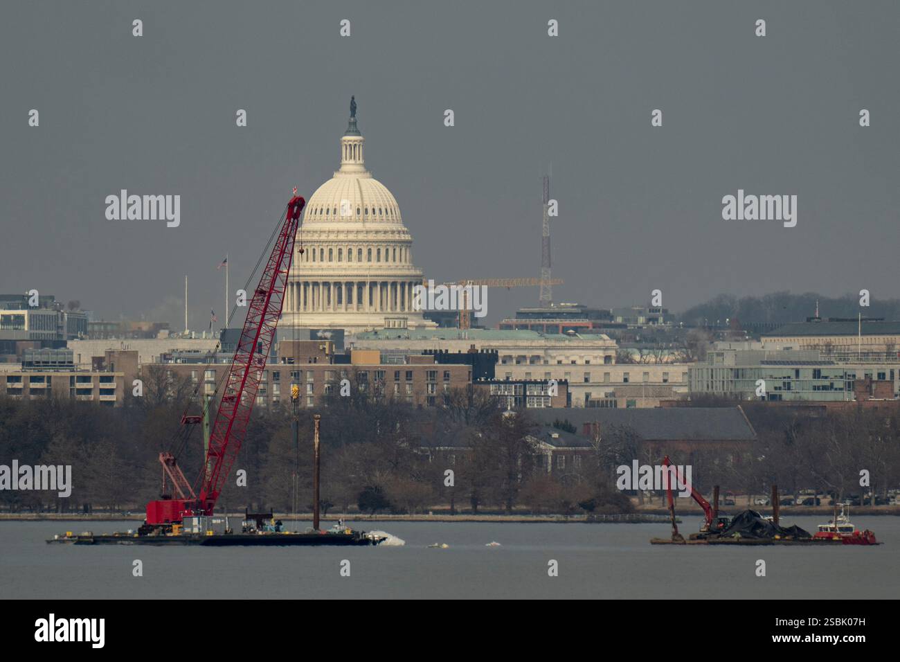 Salvage crews work on the Potomac River with the Capitol behind them ...