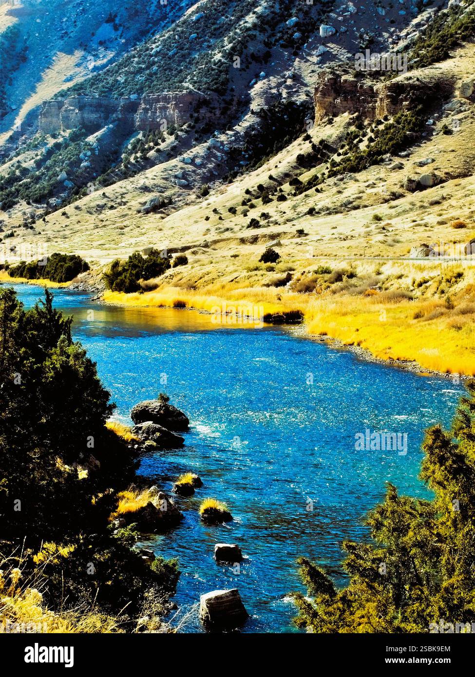 Vibrant blue Wind River Canyon, Wyoming and golden shoreline. Stock Photo