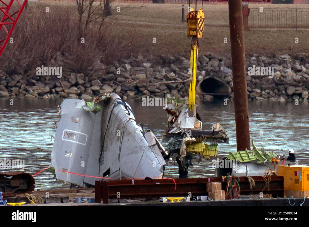 Rescue and salvage crews pull up airplane wreckage from an American ...