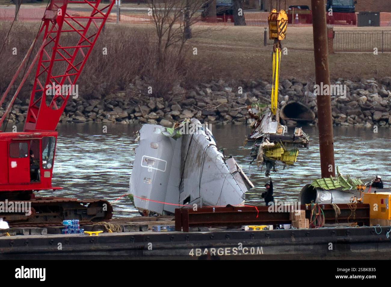 Rescue and salvage crews pull up airplane wreckage from an American ...