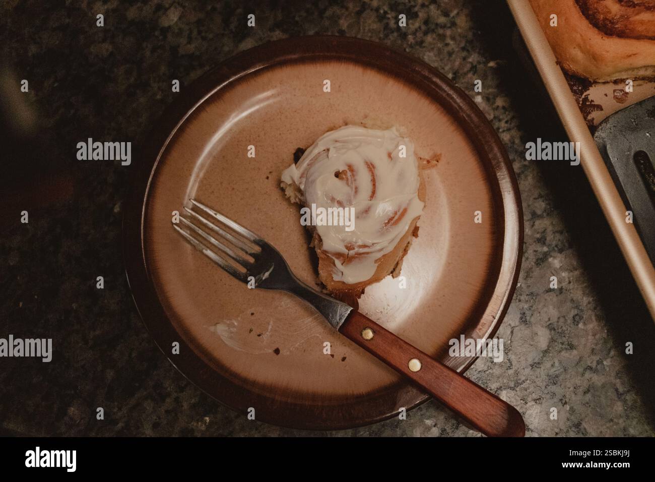 Close-Up of Cinnamon Roll on Plate with Fork Stock Photo