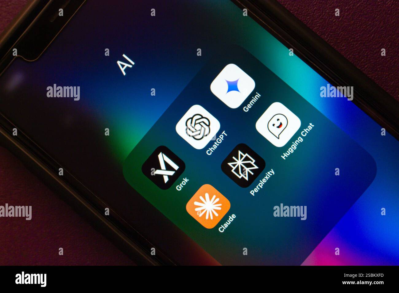 Grok AI, ChatGPT, Google Gemini, Claude, Perplexity, and Hugging Chat apps are shown on an iPhone. Modern generative AI chatbot service concept image. Stock Photo
