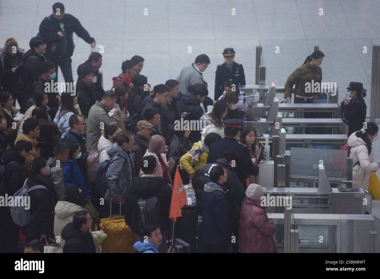 Travelers pass boarding gates at a railway station in Hangzhou in east