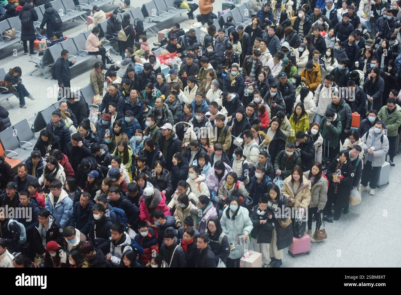 Travelers wait for their trains at a railway station in Hangzhou in