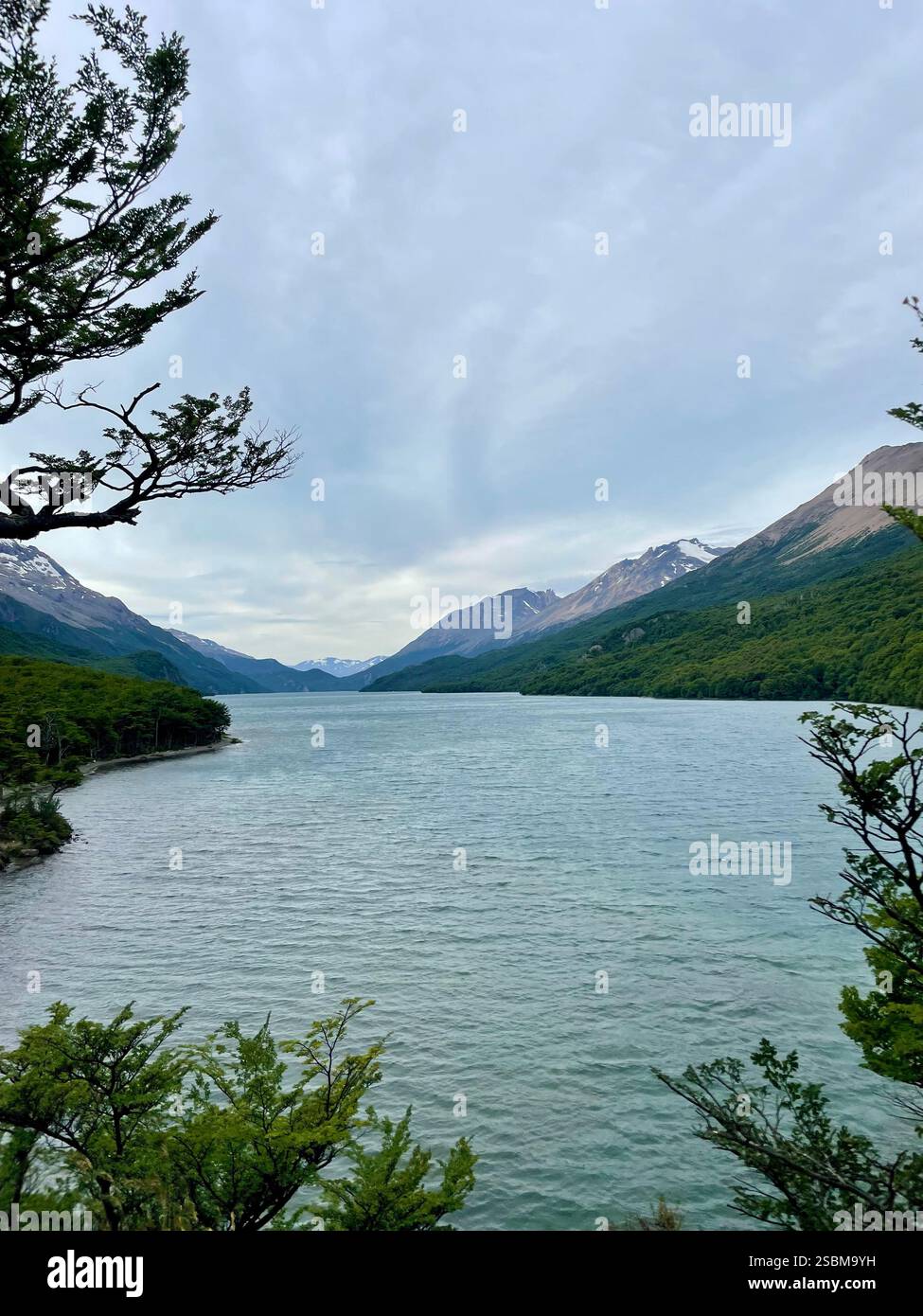 Where de mountains stand tall, the water flows calmly, and nature whispers serenity - a peaceful retreat for the soul. - Smartphone Captured Stock Image