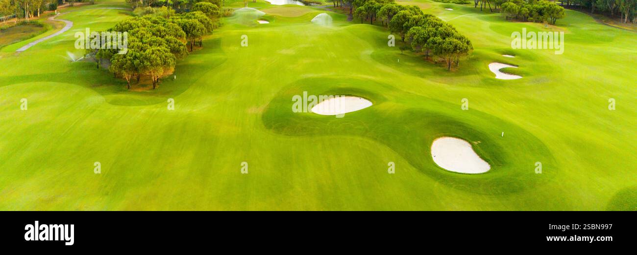A panoramic view of a golf course with sand traps and lush greenery ...