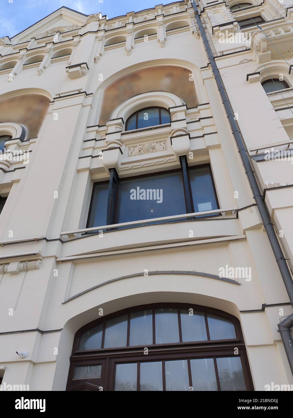 A close-up of a historic building facade featuring large arched windows ...