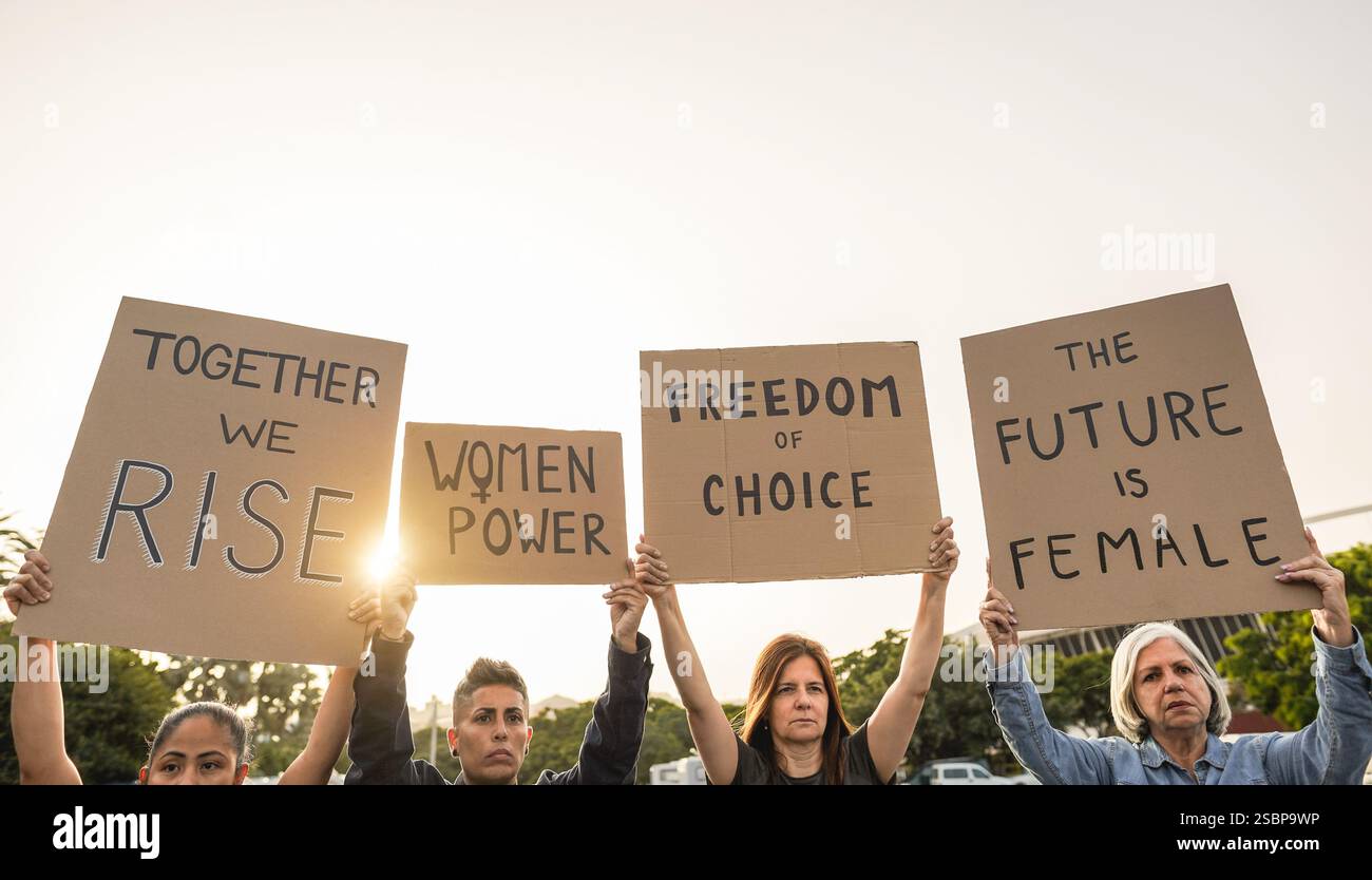 Multiracial women doing demonstration for female rights on city street ...