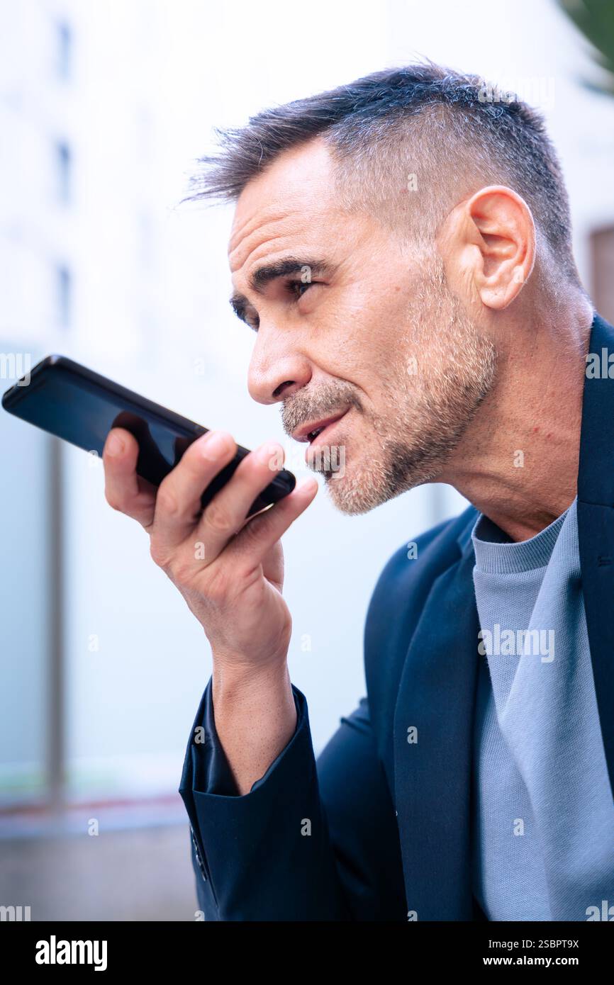 Businessman Using Voice Command on Smartphone Outdoors.Vertical Stock Photo