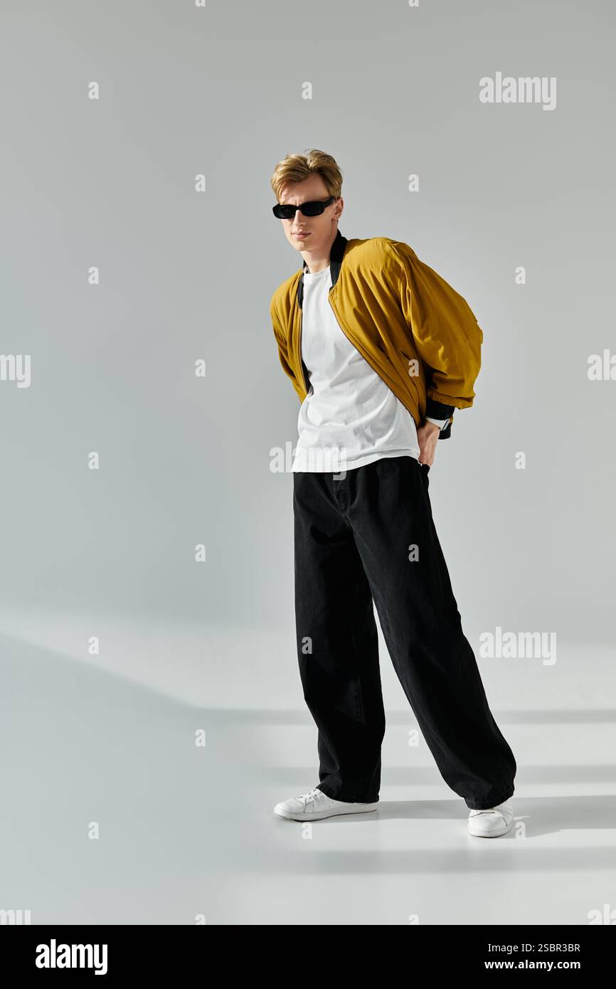 A young man exudes confidence while striking a pose in fashionable ...