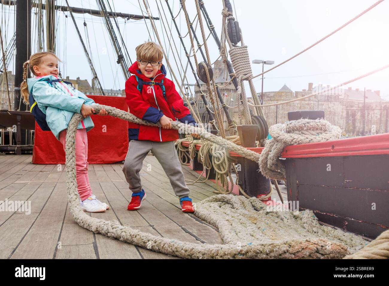 Tuggig Rope Energetic kids enjoy tugging a hefty rope on deck of pirate ship Stock ...