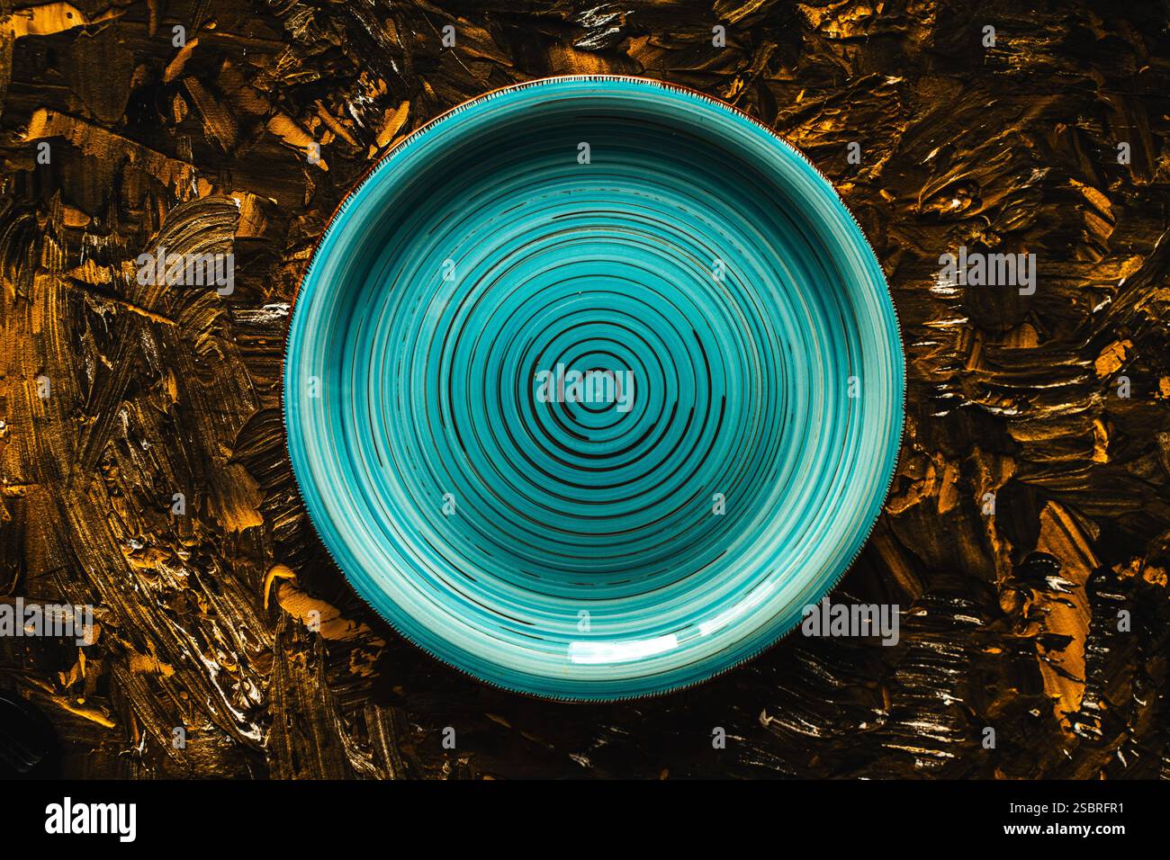 Turquoise plate empty on brown with gold background. Top view, space for text. High quality photo Stock Photo