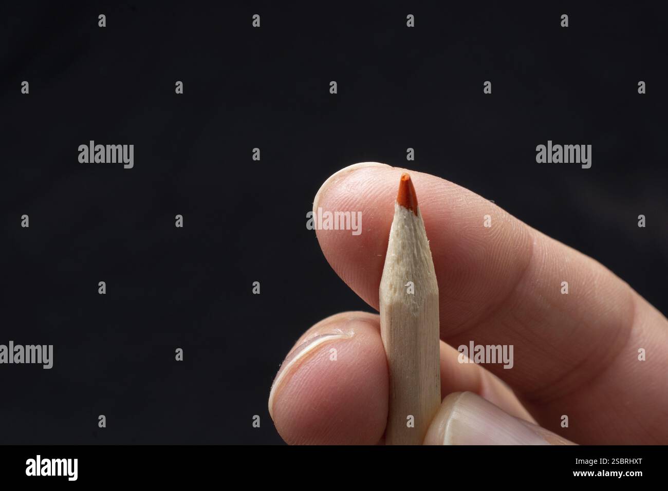 Hand holding a red colored pencil Stock Photo