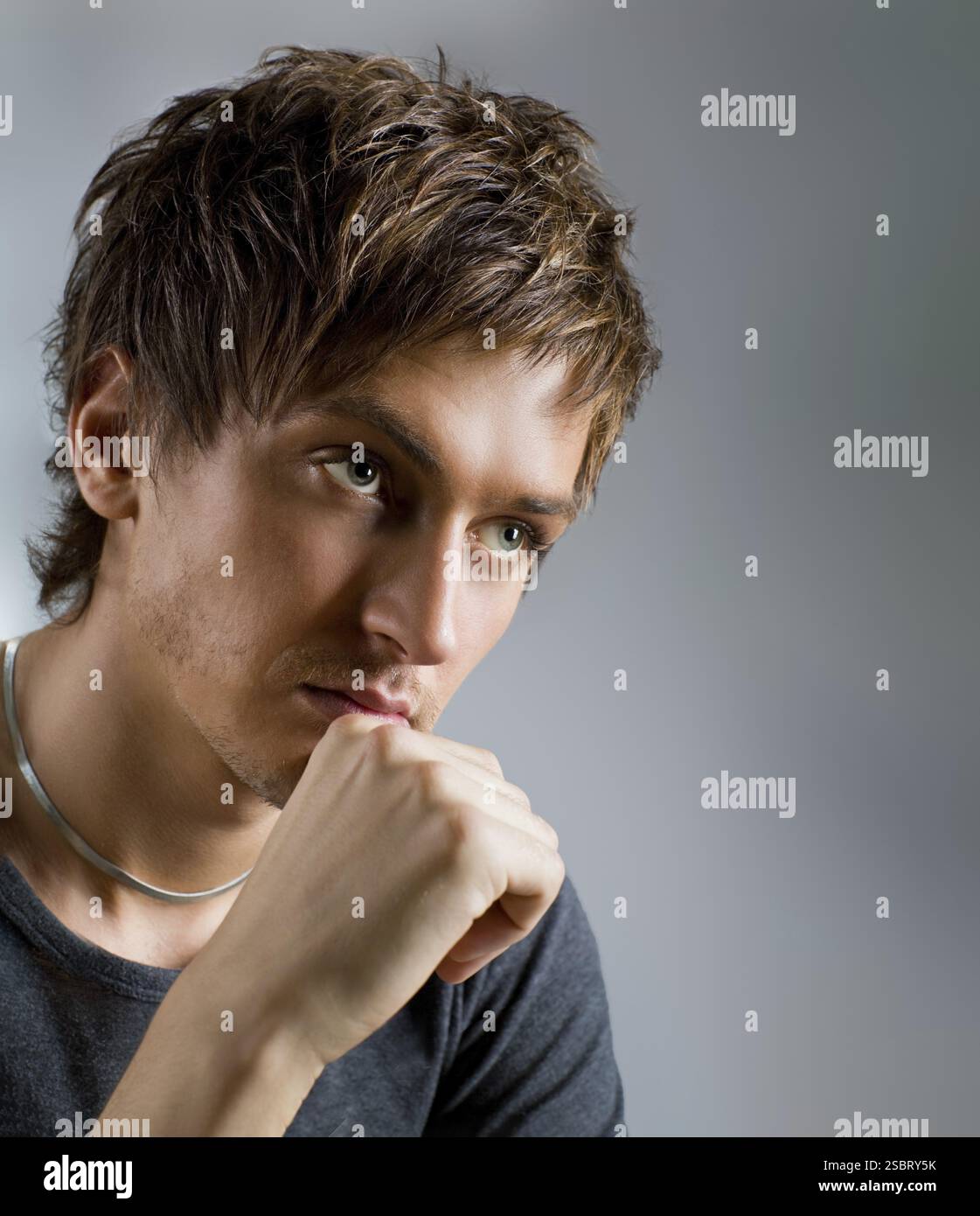 Close-up portrait of a handsome guy, at gray background Stock Photo