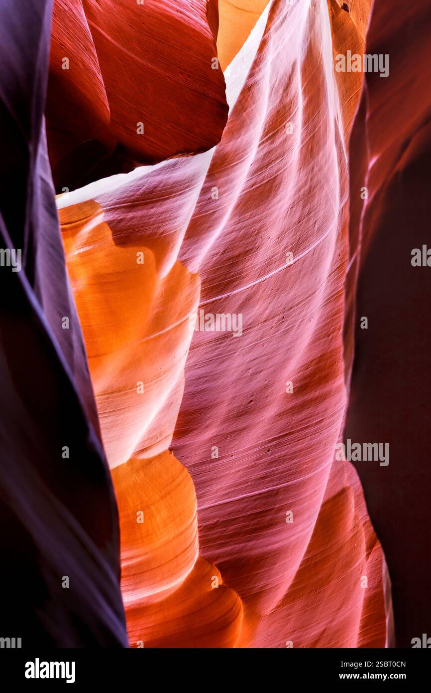 A rock formation with orange and red colors. The rock is curved and has ...