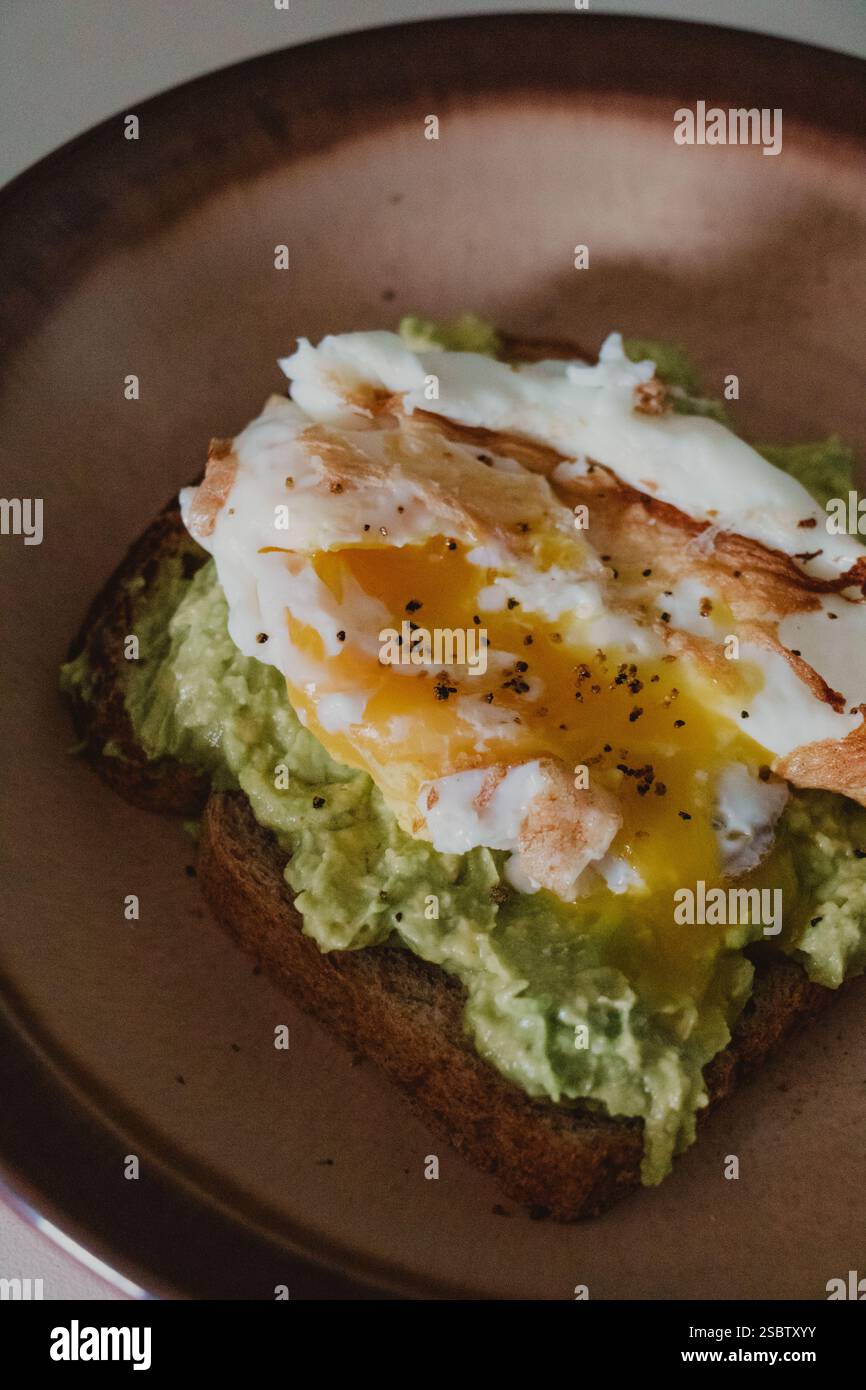 Avocado Toast with Fried Egg on a Plate Stock Photo