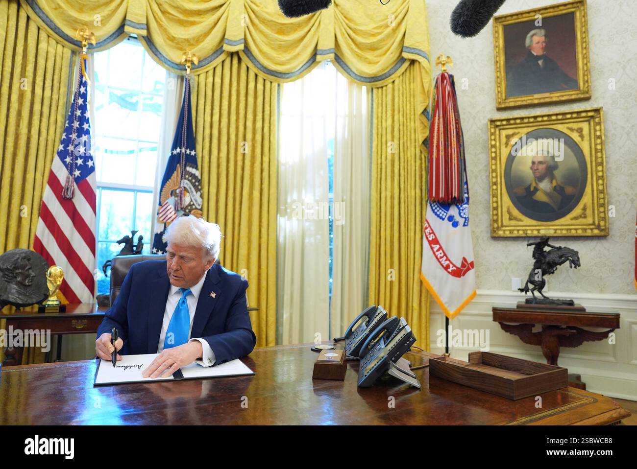 President Donald Trump signs executive orders in the Oval Office of the