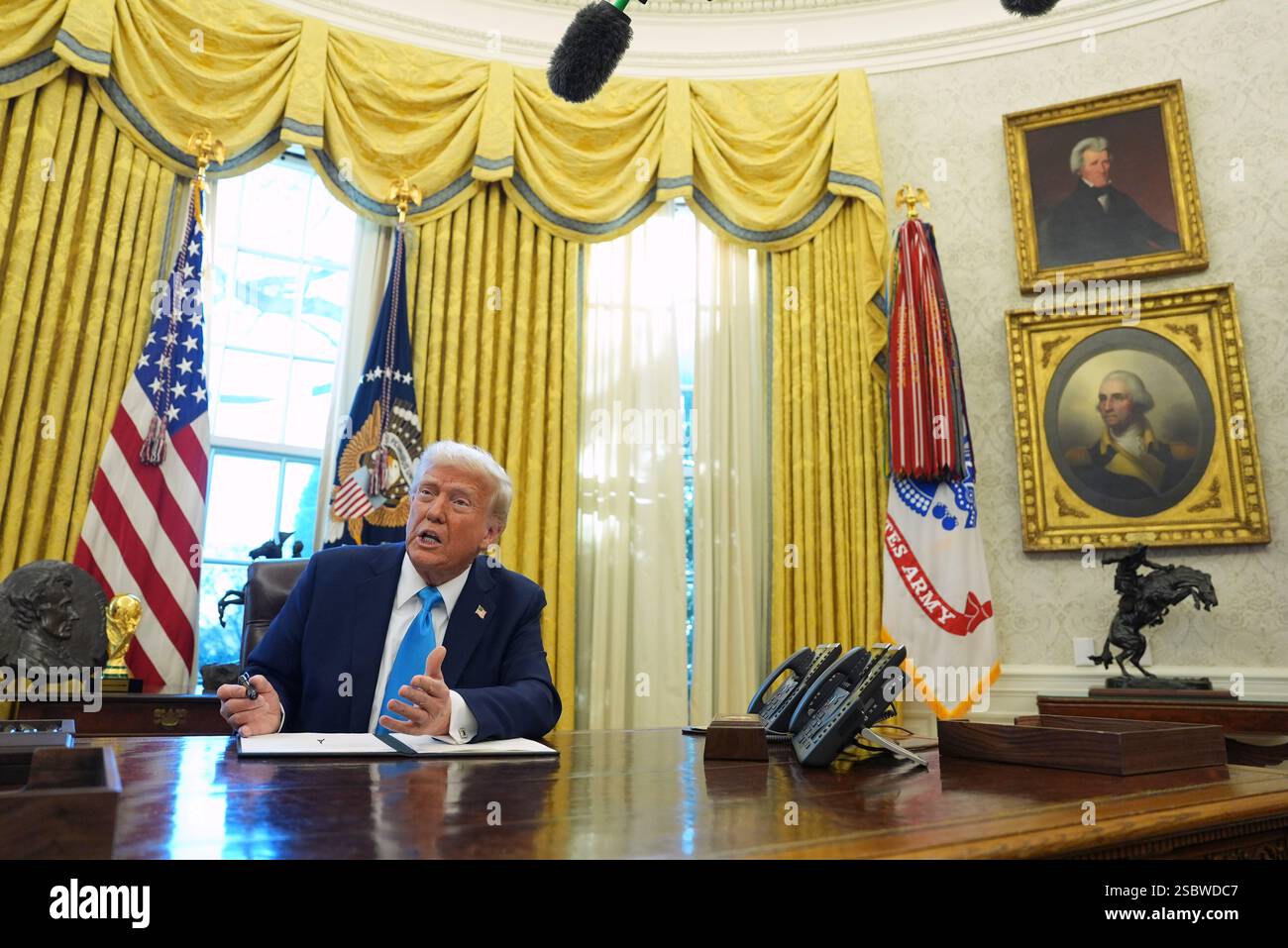 President Donald Trump speaks to reporters as he signs executive orders