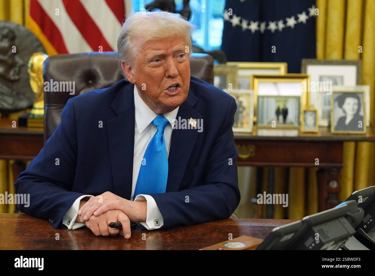 President Donald Trump speaks to reporters as he signs executive orders