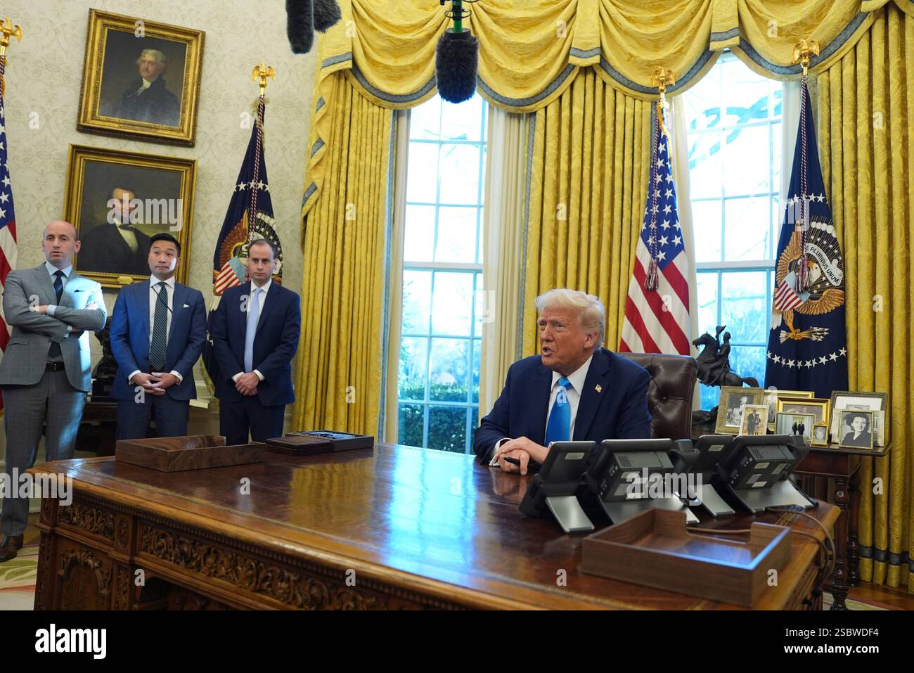 President Donald Trump speaks to reporters as he signs executive orders