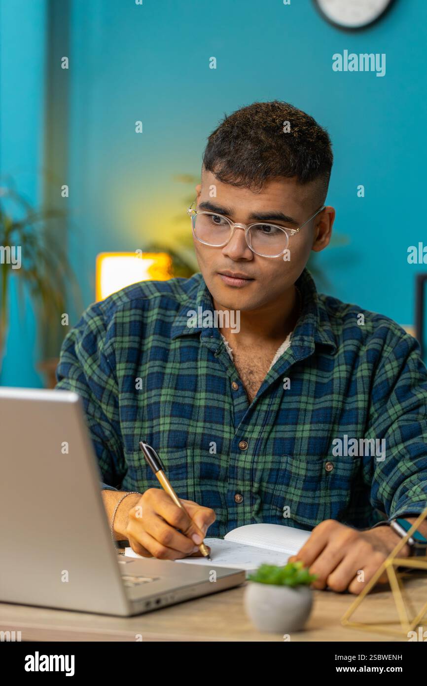 Indian man student freelancer study with notebook write notes making ...