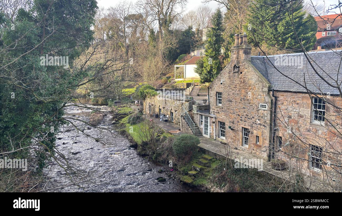 Old riverside house on The Water of Leith river in central Scotland. Waterway with walk along side. Runs through the centre of Edinburgh - Smartphone Captured Stock Image