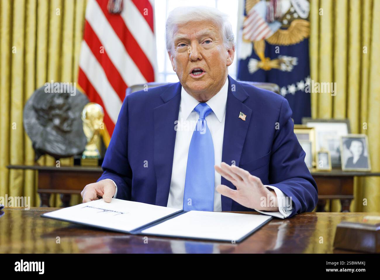 US President Donald J. Trump talks to reporters and signs a series of