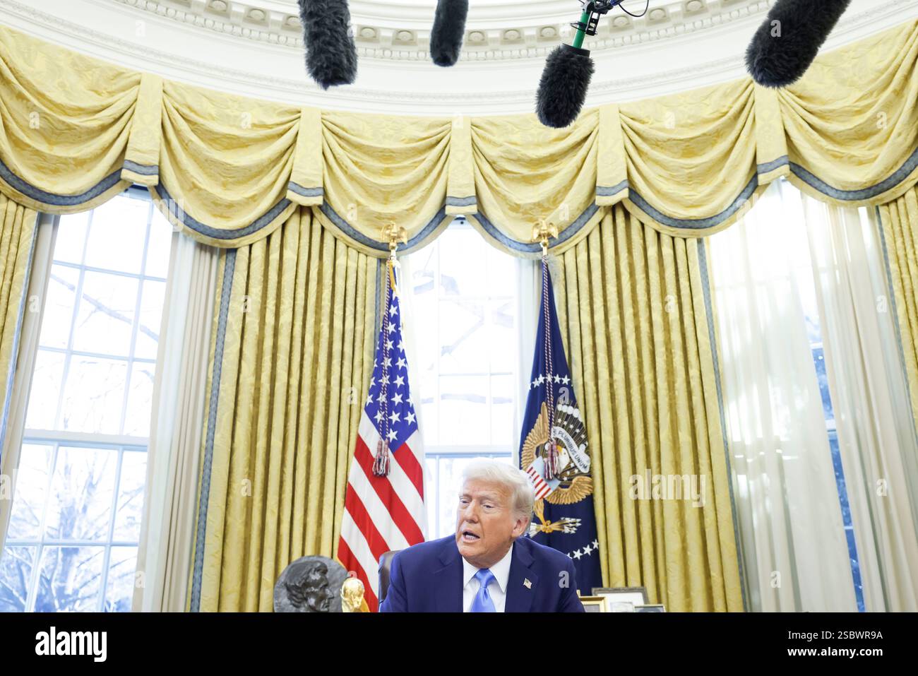 US President Donald J. Trump talks to reporters and signs a series of
