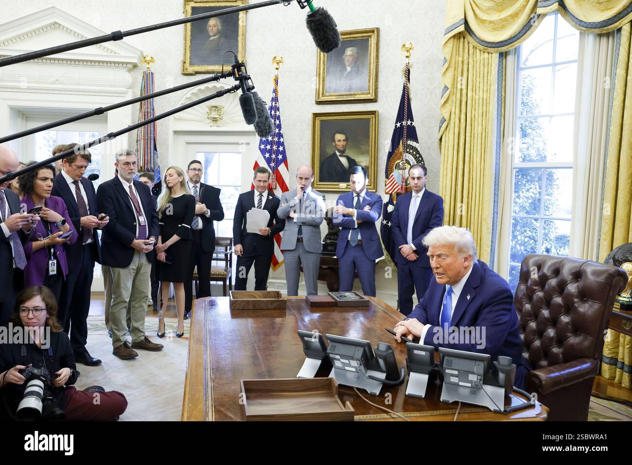 US President Donald J. Trump talks to reporters and signs a series of