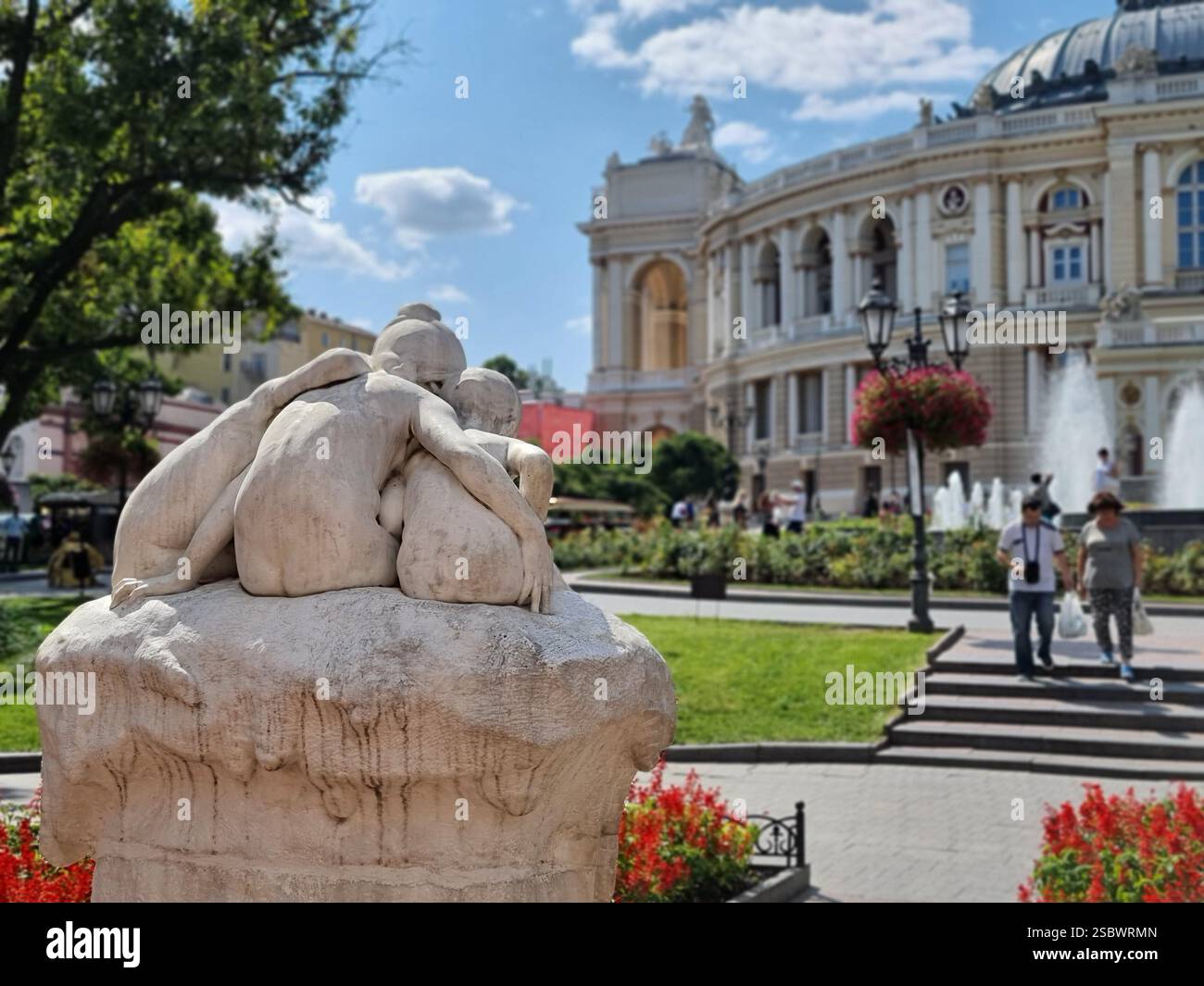 Sculpture-fountain "Youth" a.k.a. Children and the Frog or Narcissus in front of the opera of Odesa / Odessa seen from the back at daytime; conceptual - Smartphone Captured Stock Image
