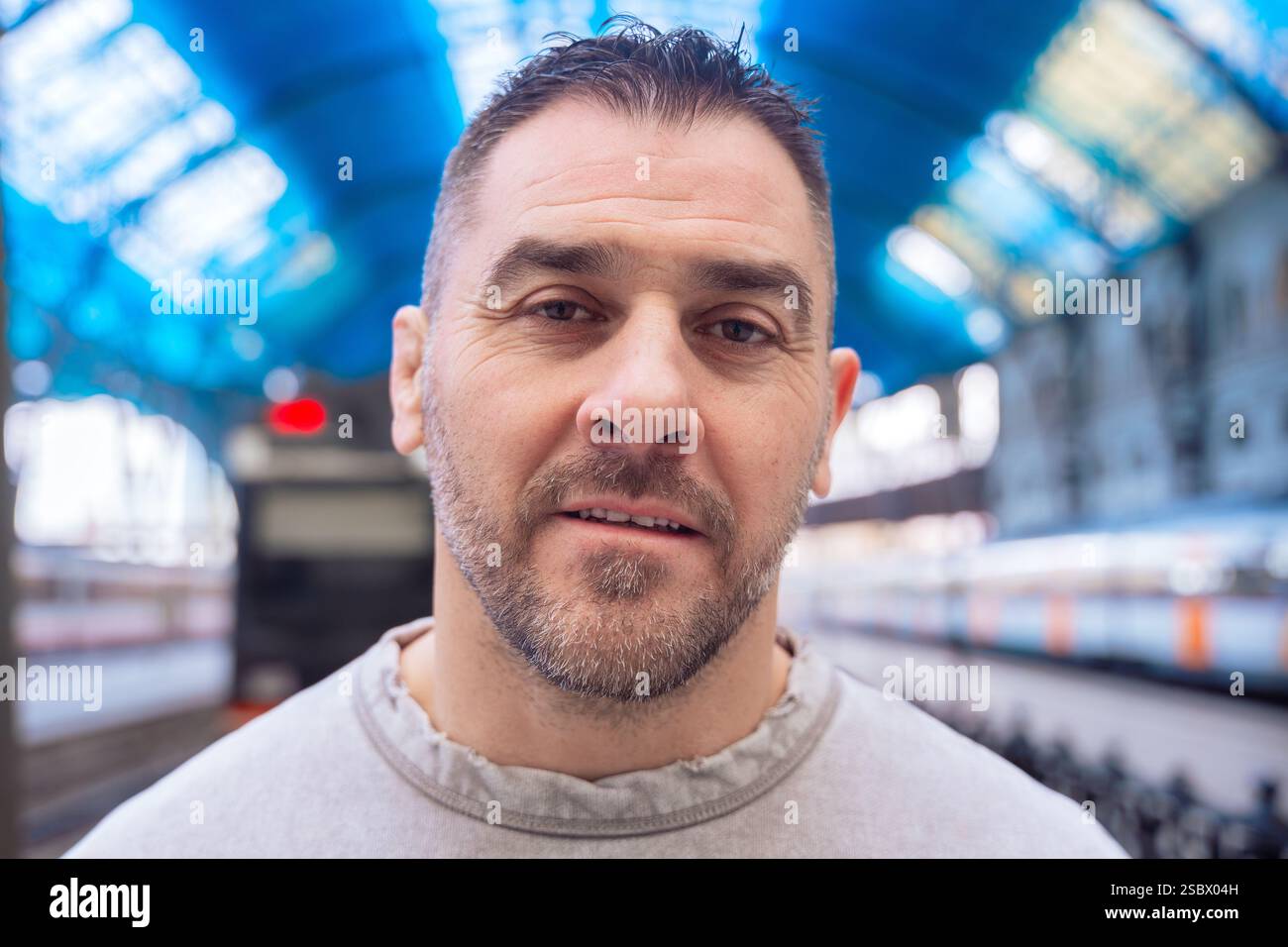 Thoughtful Man Looking Up at Train Station looking at camera Stock Photo