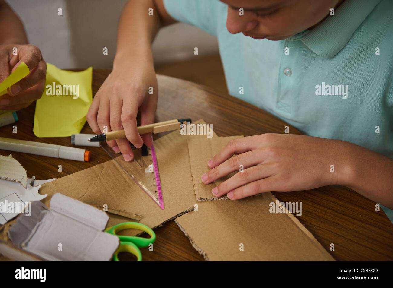 A young student creating a craft project using recycled cardboard and ...