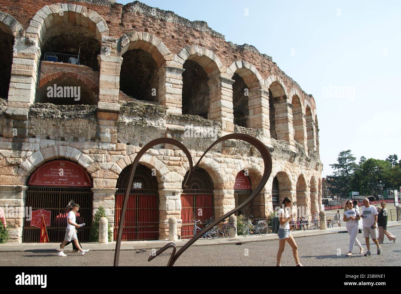 A metal heart with the majestic Arena di Verona amphitheatre as background but showing its beauty Stock Photo